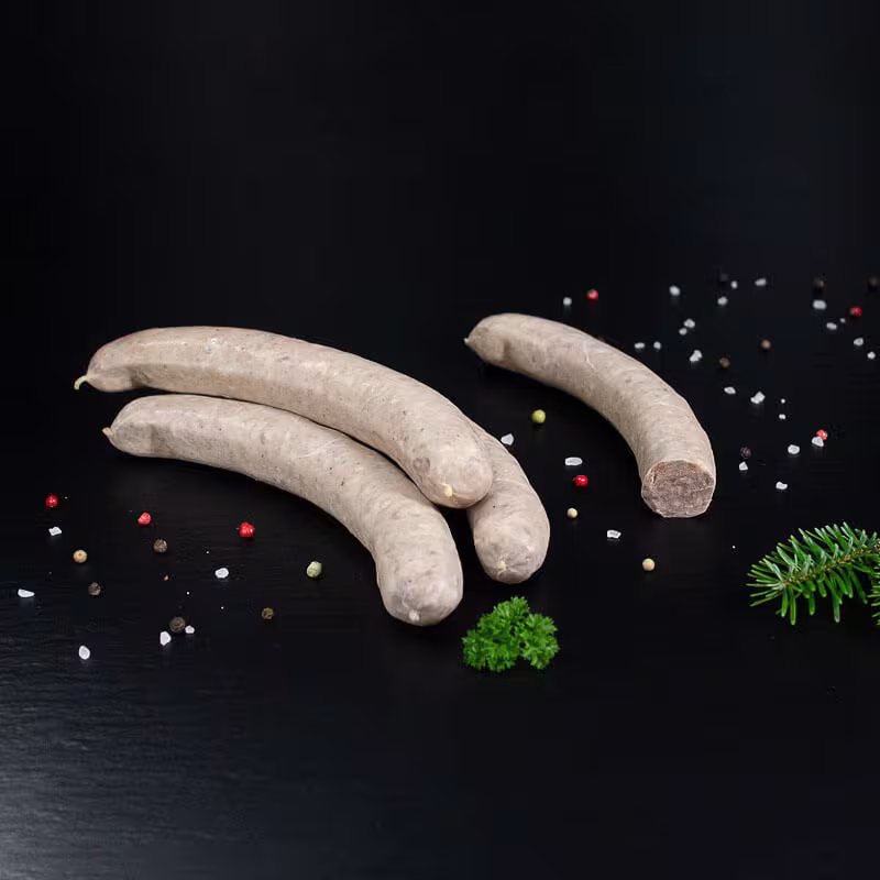 Wildbratwurst Natur (grob) mit Kräutern und Gewürzen auf dunklem Untergrund