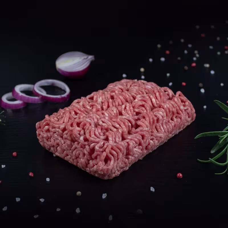 Rohes gemischtes Wildhackfleisch mit Kräutern und Gewürzen auf dunklem Untergrund