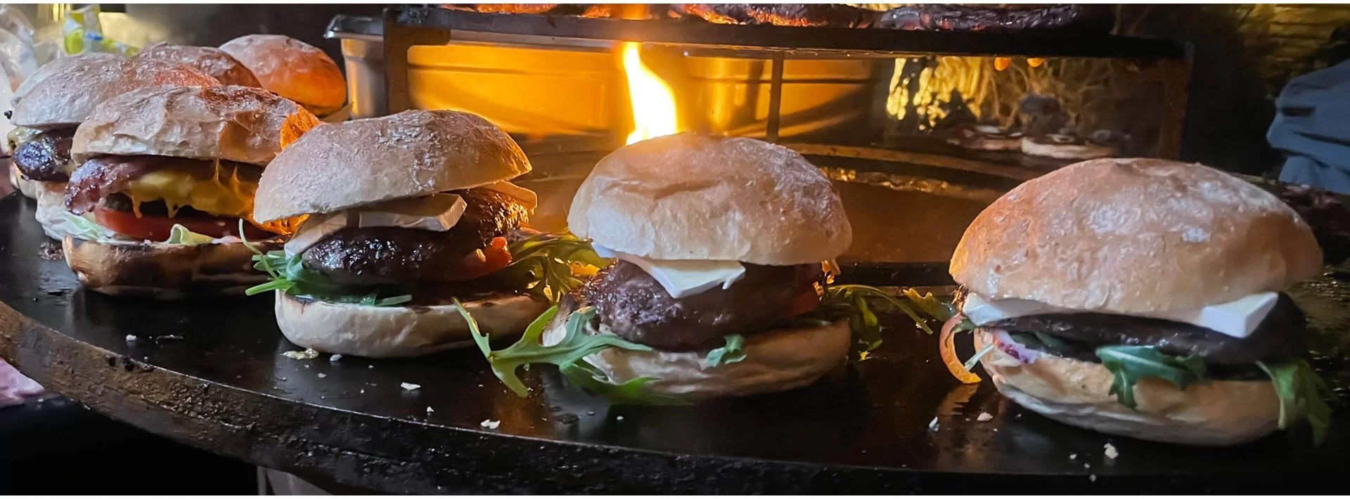 Wildburger mit Salat, Tomate und Käse am Grill im Banner der Wildburger-Kategorie