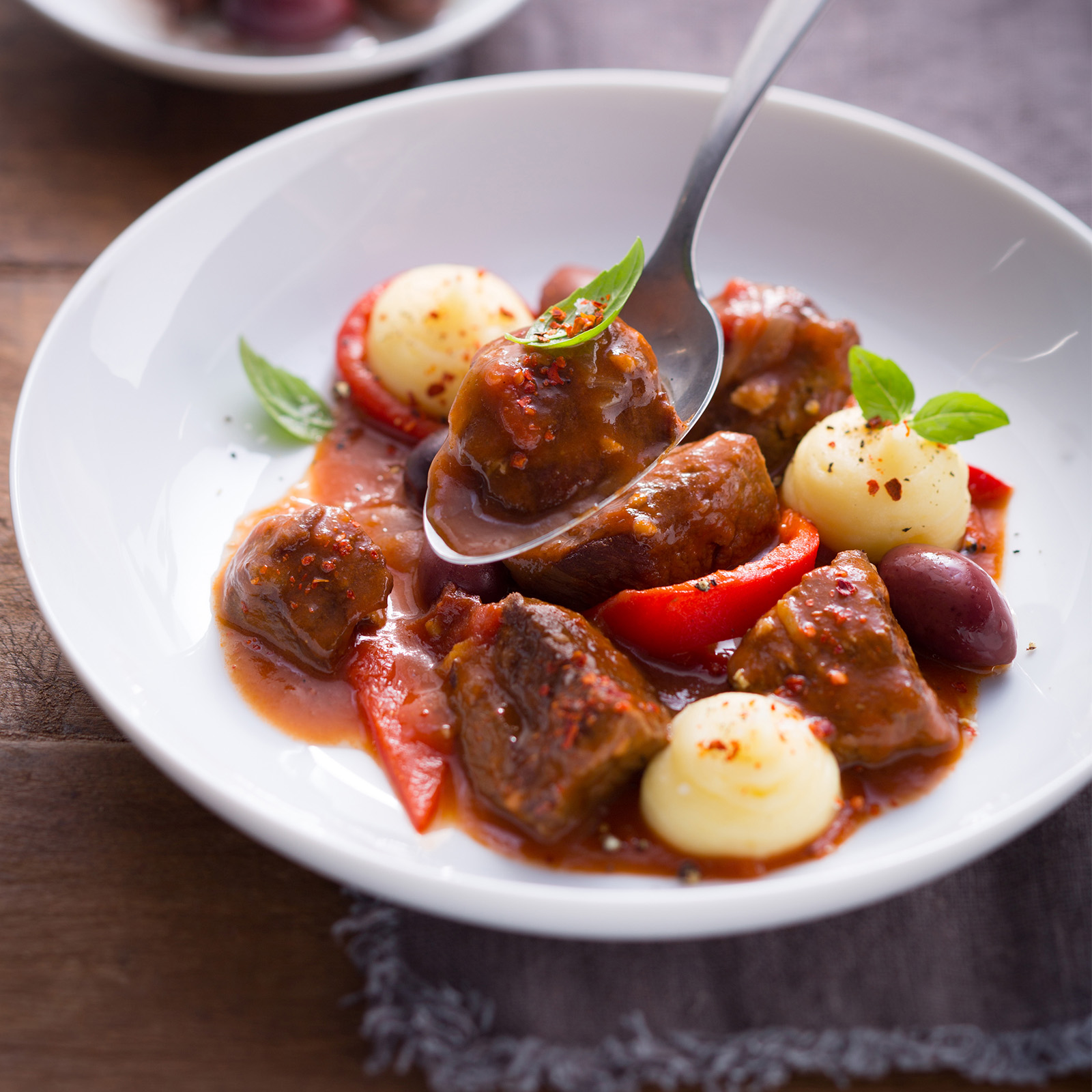 Baskischer Hirschtopf mit gerösteten Paprikaschoten, Kalamata-Oliven, Tomaten und Basilikum
