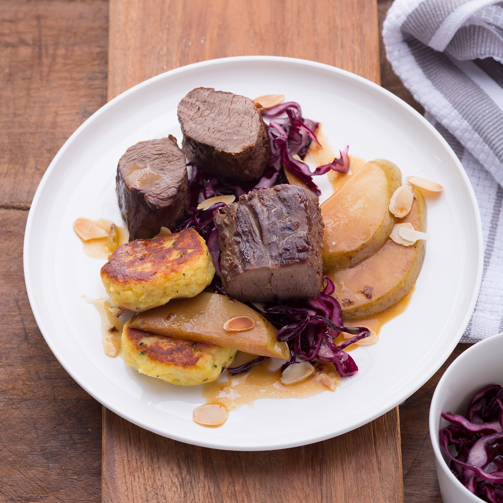 Hirschfilet mit gebratenen Birnenspalten, gerösteten Mandelblättchen, Rotkohl und Polentaküchlein