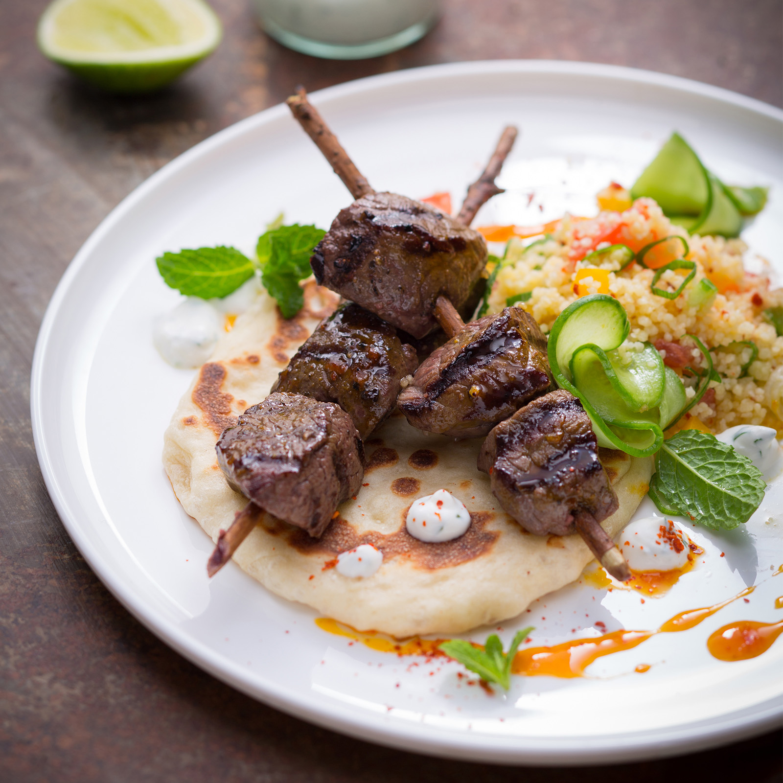 Hirsch-Kebab-Spieße auf Fladenbrot mit Tabbouleh, Joghurtdip, Minze und Limette