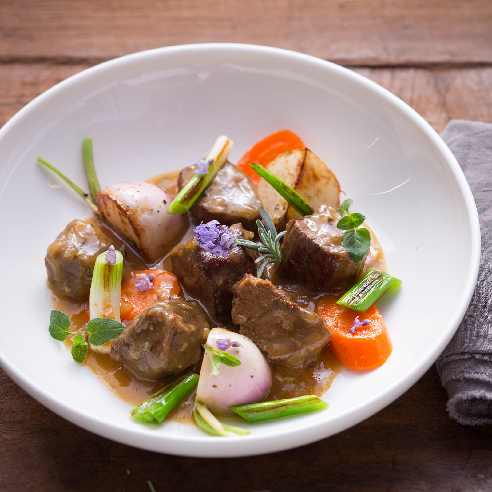 Provenzalisches Hirschragout mit weißen Rübchen, Karotten, Frühlingszwiebeln und Kräuterblüten