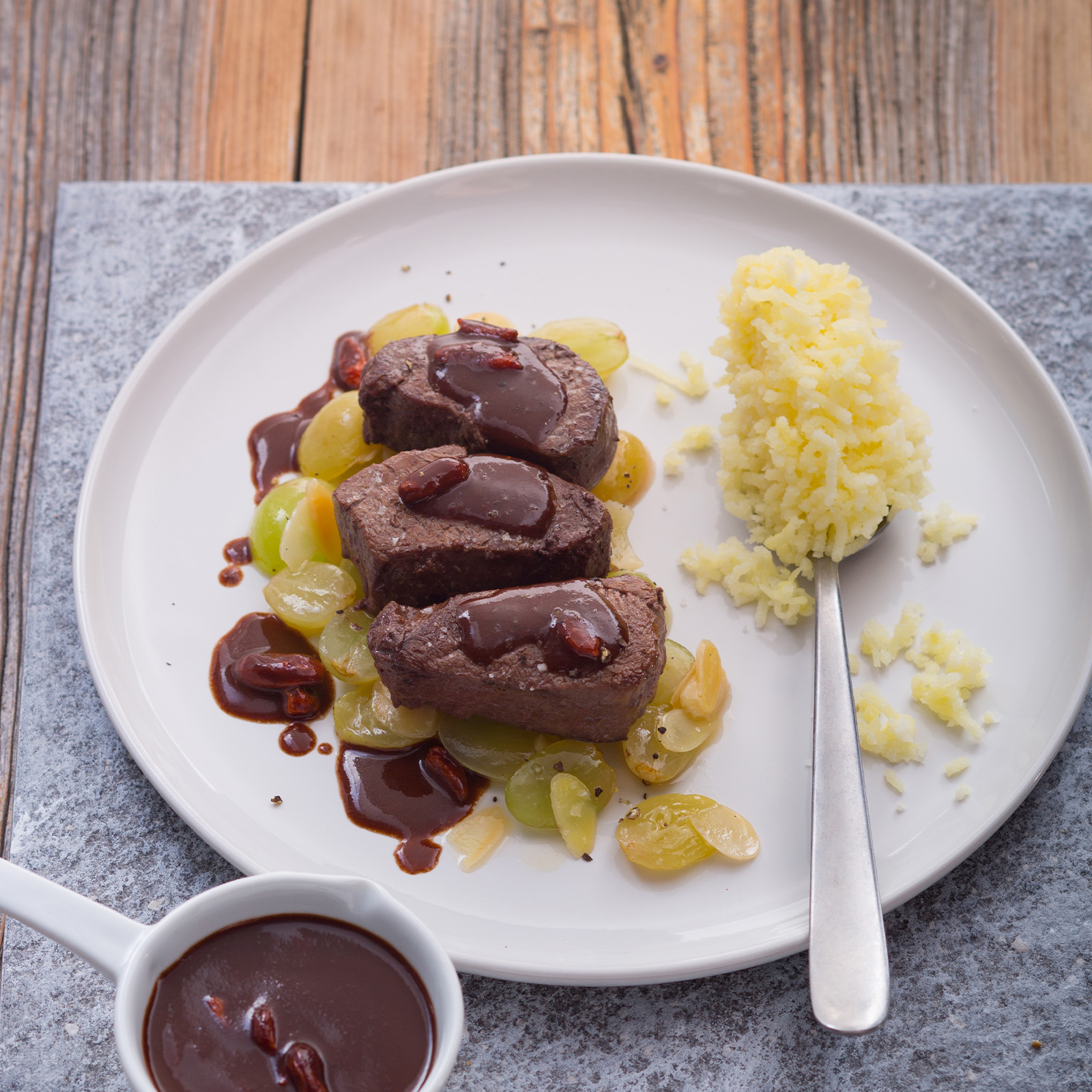 Hirschmedaillons mit dunkler Schokosauce, Gojibeeren, glasierten Trauben und Safranreis