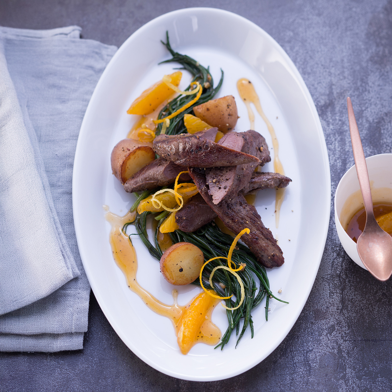 Rehfilets mit Orangensauce, Orangenfilets, Zitruszesten, Drillingen und grünen Bohnen