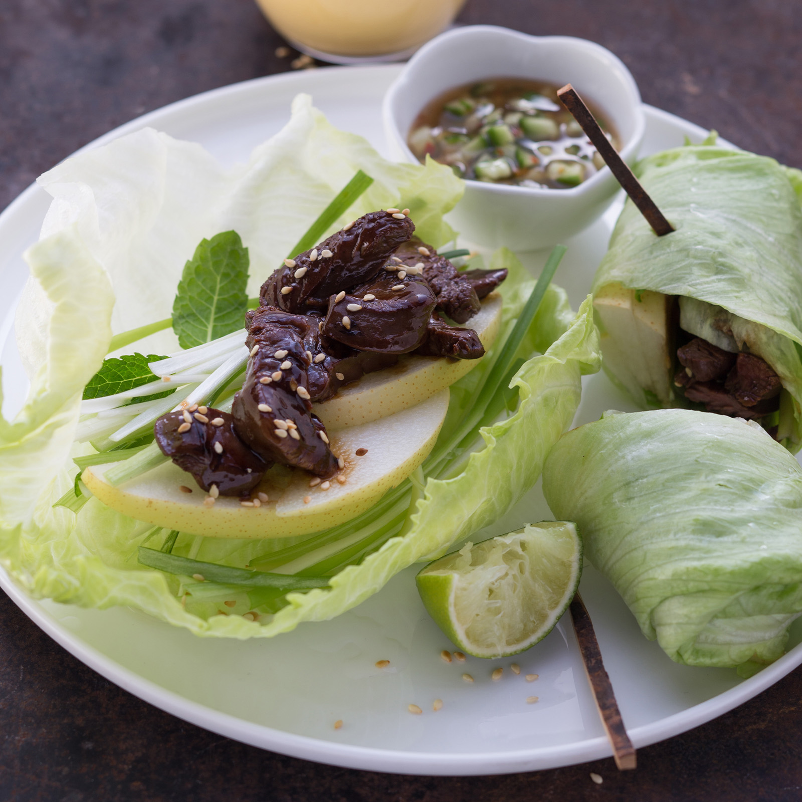 Asia-Salatrollen aus Eissalatblättern gefüllt mit mariniertem Rehfilet, Nashi-Birne und Limette