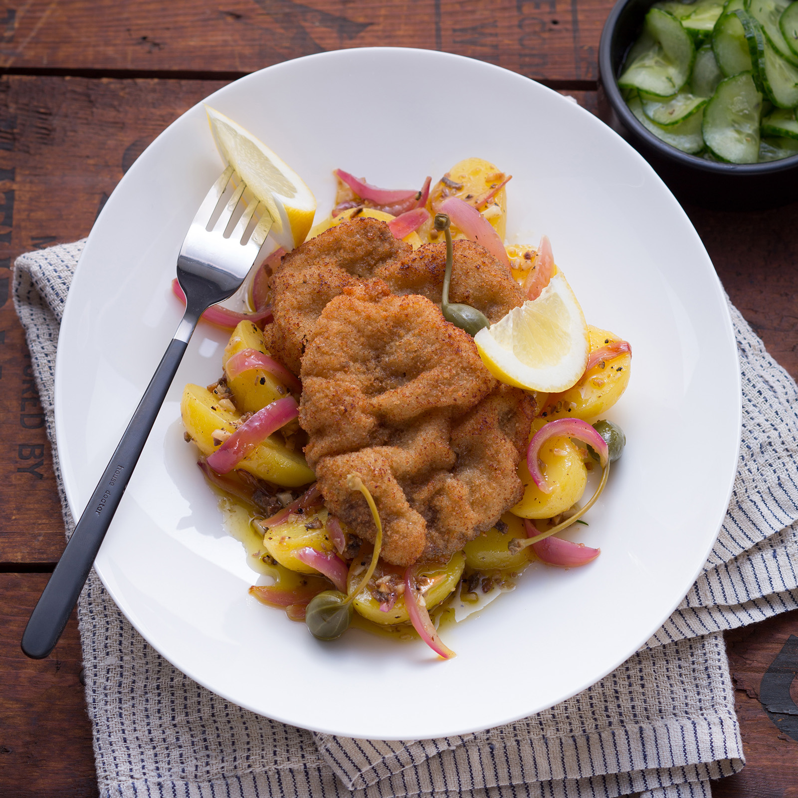 Goldbraun paniertes Rehschnitzel Wiener Art mit Zitronenspalte, Kapernäpfeln und Kartoffelsalat