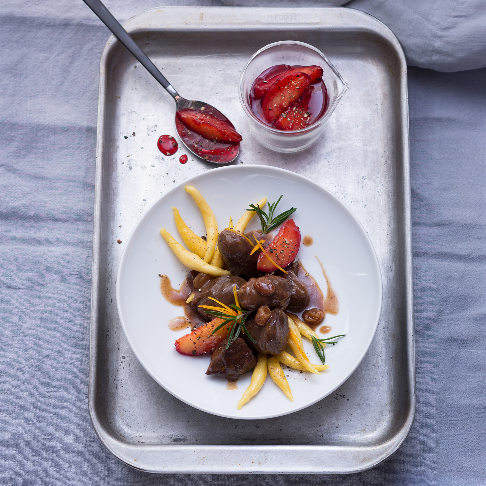 Mariniertes Wildschweinragout mit Rotwein, Schupfnudeln, Rotweinpflaumen, Rosmarin und Orangenzesten