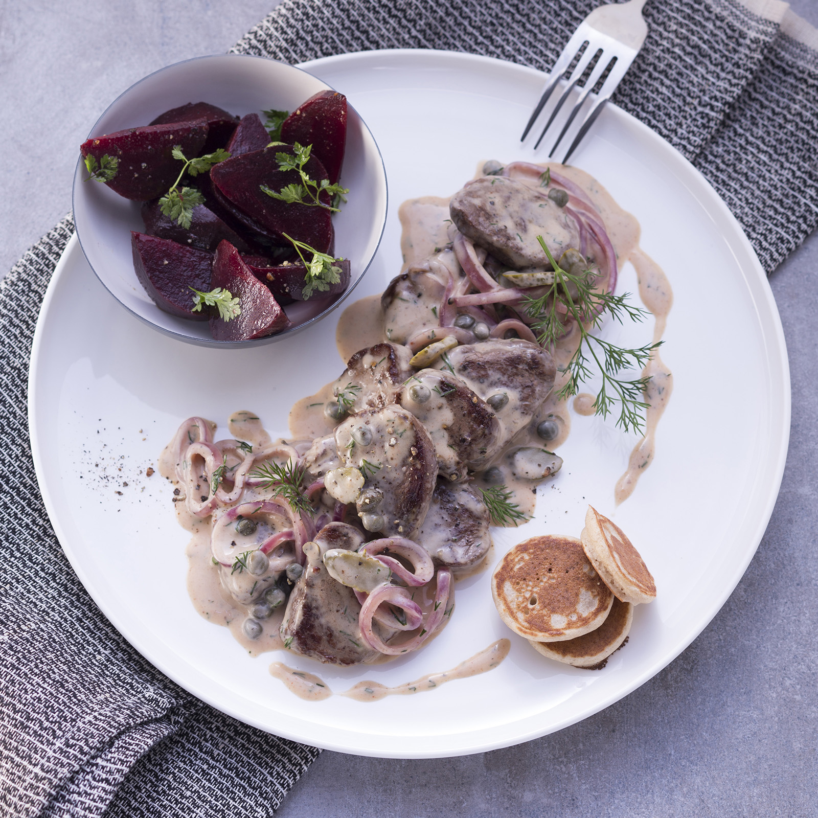 Wildschwein à la Stroganoff in heller Rahmsauce mit Kapern, Dill und roten Zwiebeln, dazu eine Schale Rote Bete