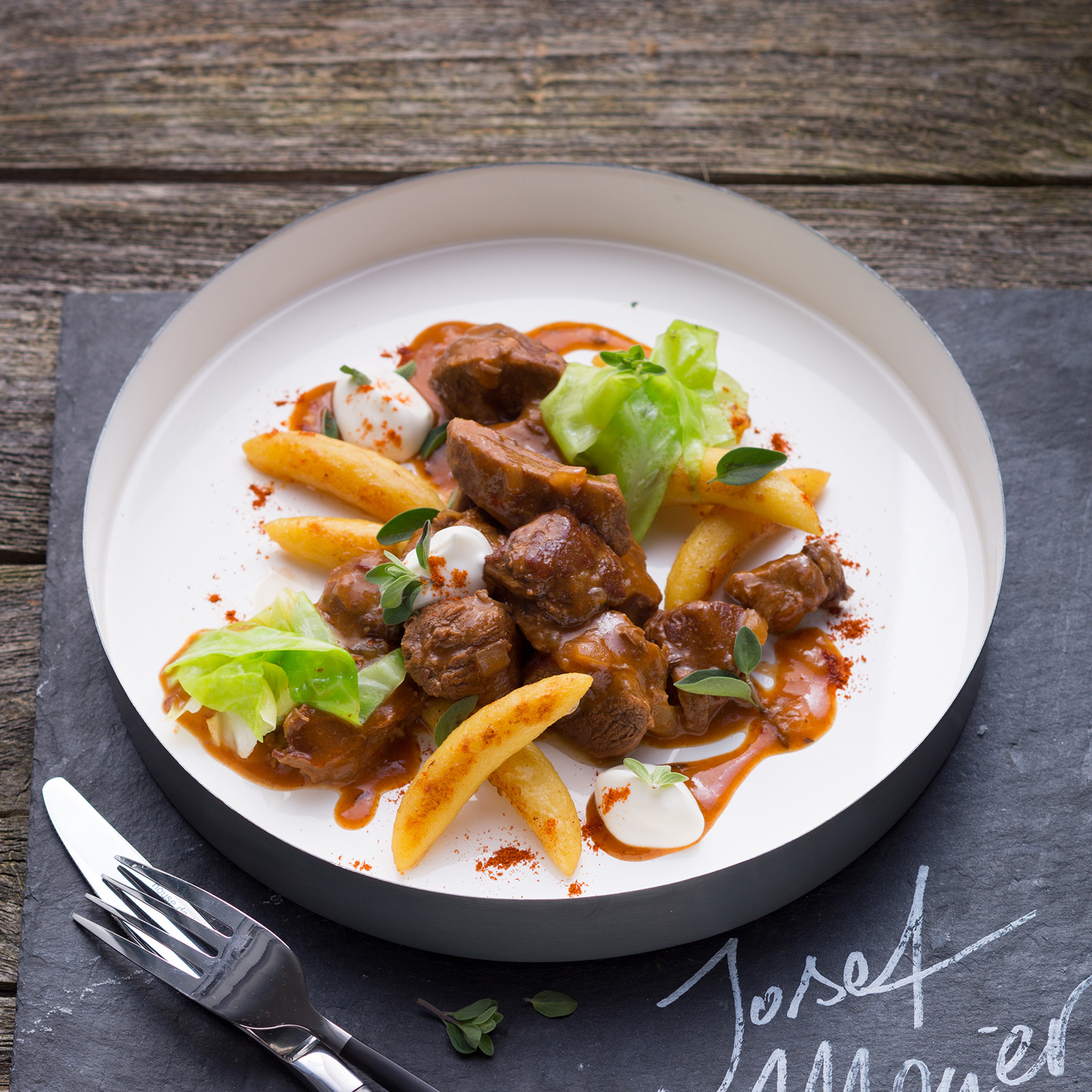 Wildschweingulasch in Paprikasauce mit Schupfnudeln, Spitzkohl, Majoran und Sauerrahm