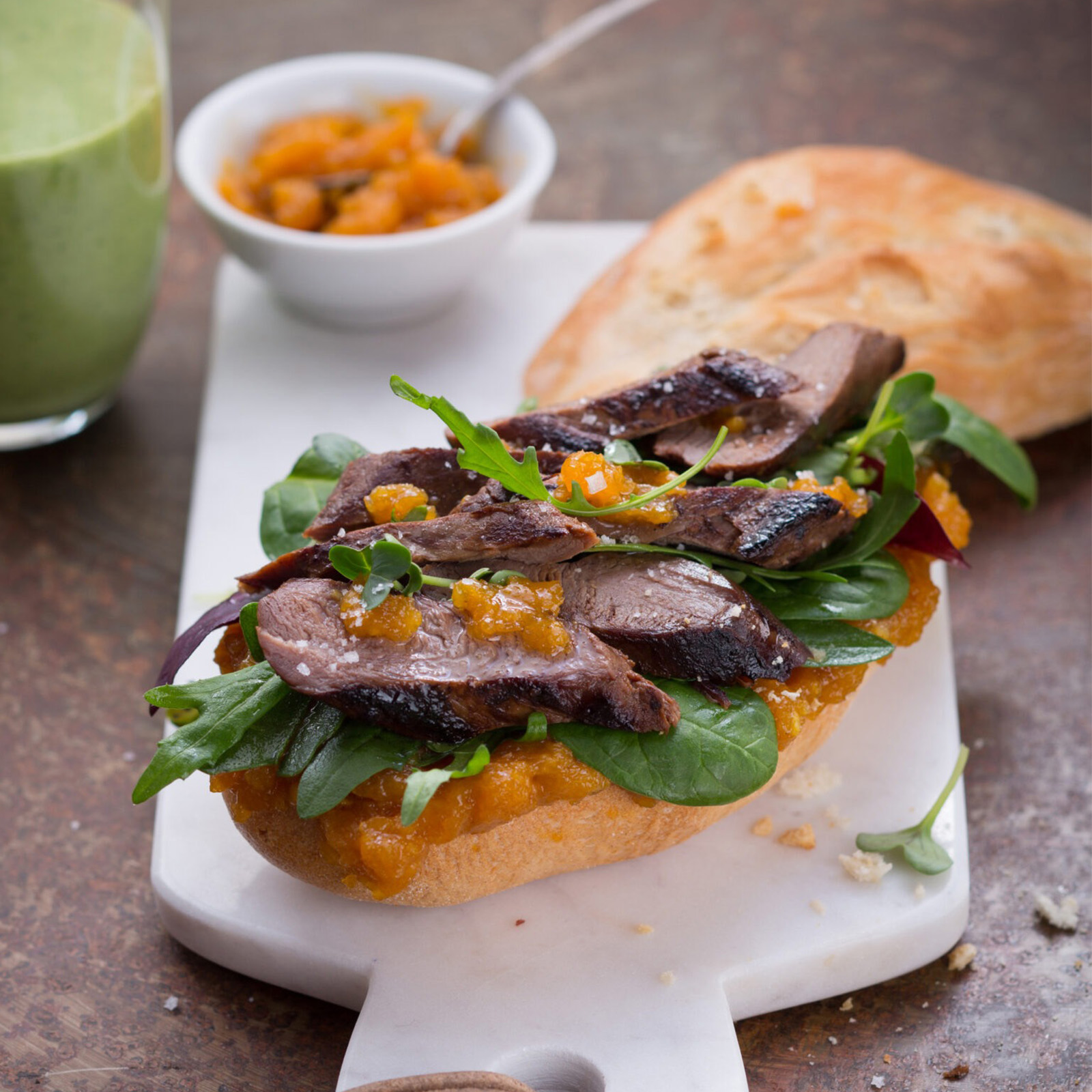 Rehfilet-Sandwich mit Aprikosenchutney, Portulak und Rucola auf geröstetem Baguette