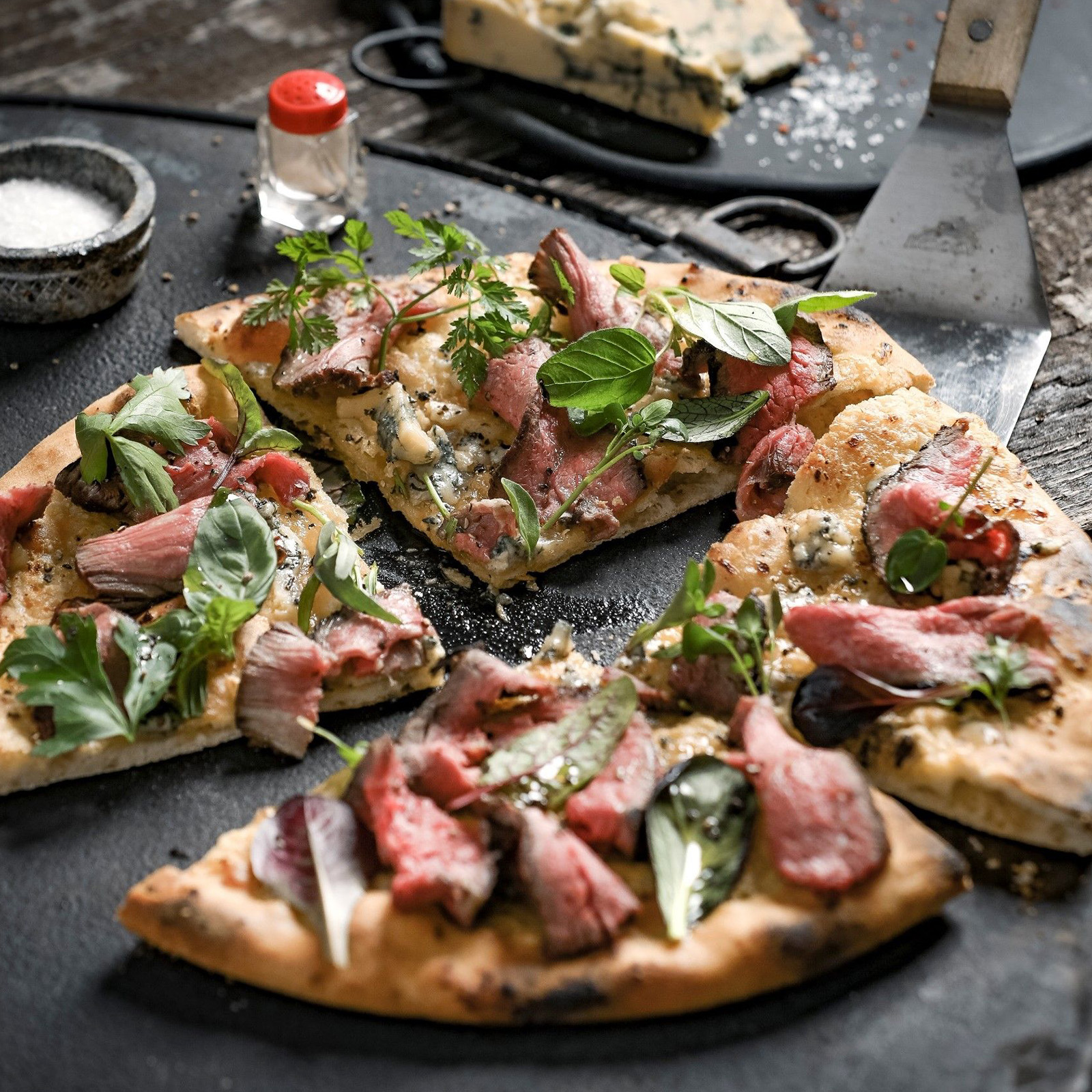 Knuspriger Flammkuchen mit Rehmedaillon-Streifen, Blauschimmelkäse und frischem Basilikum